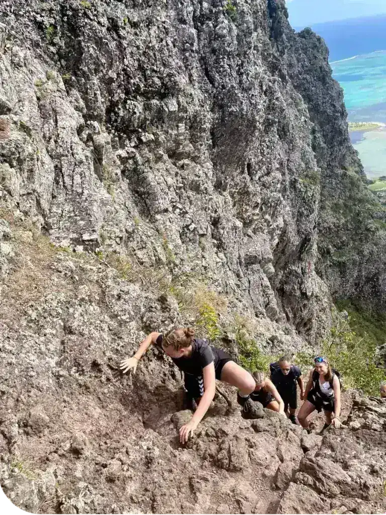 Hiker climbing the rocky Le Morne mountain trail