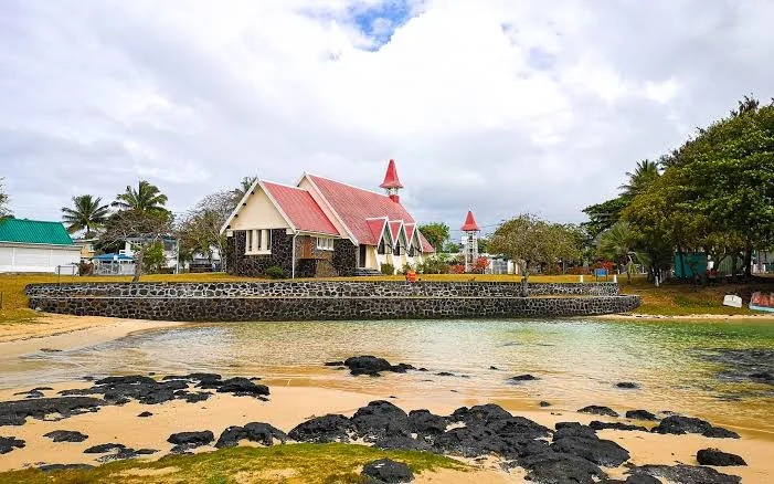 Coastal church and shoreline with calm blue water