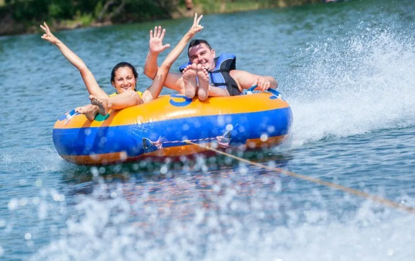 Two people smiling during a high speed tube ride